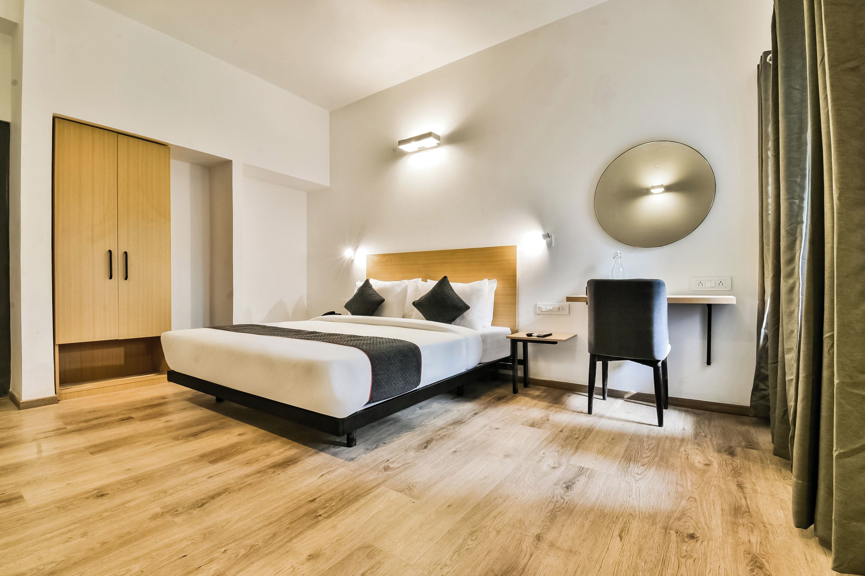 Una habitación de hotel moderna con una cama grande, mesitas de noche, un escritorio y un armario.