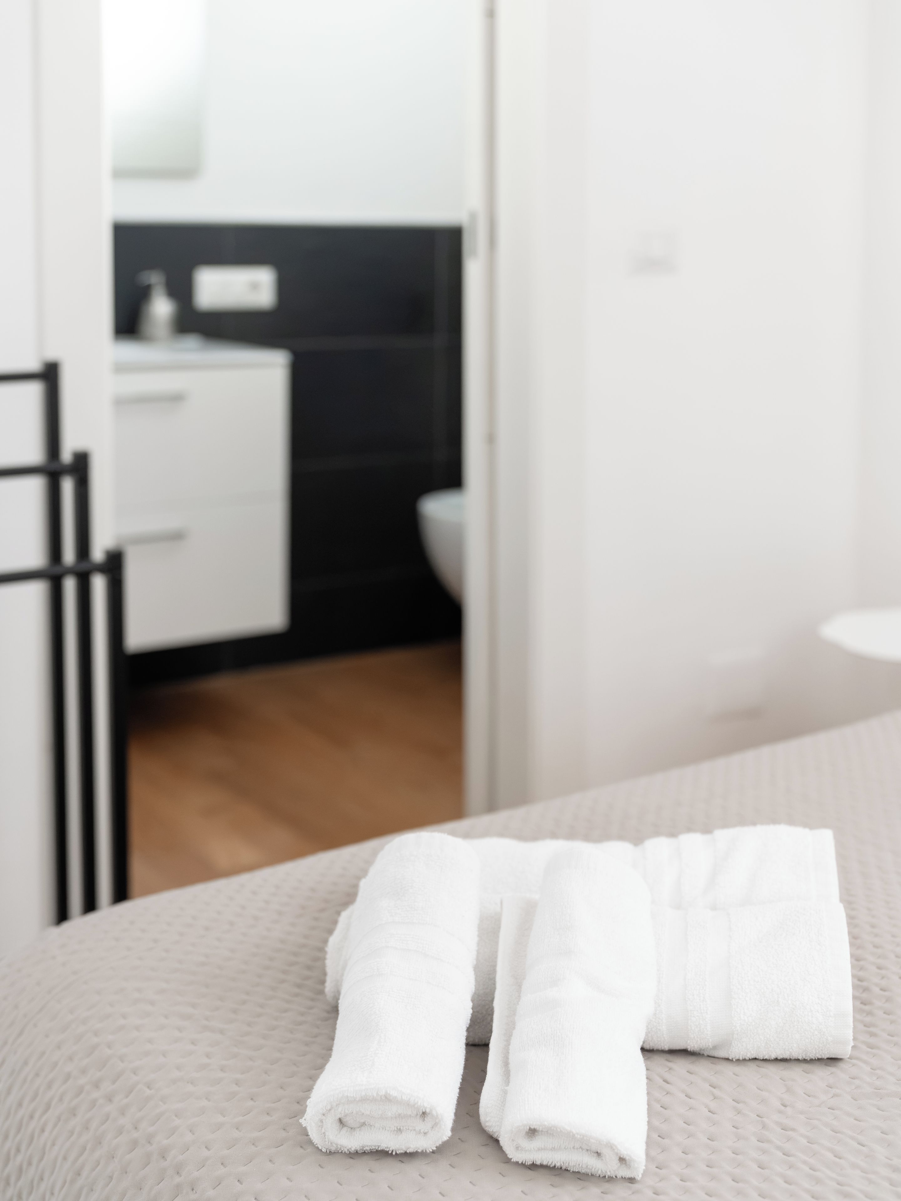 Une salle de bain avec un lavabo blanc, une serviette et des toilettes.
