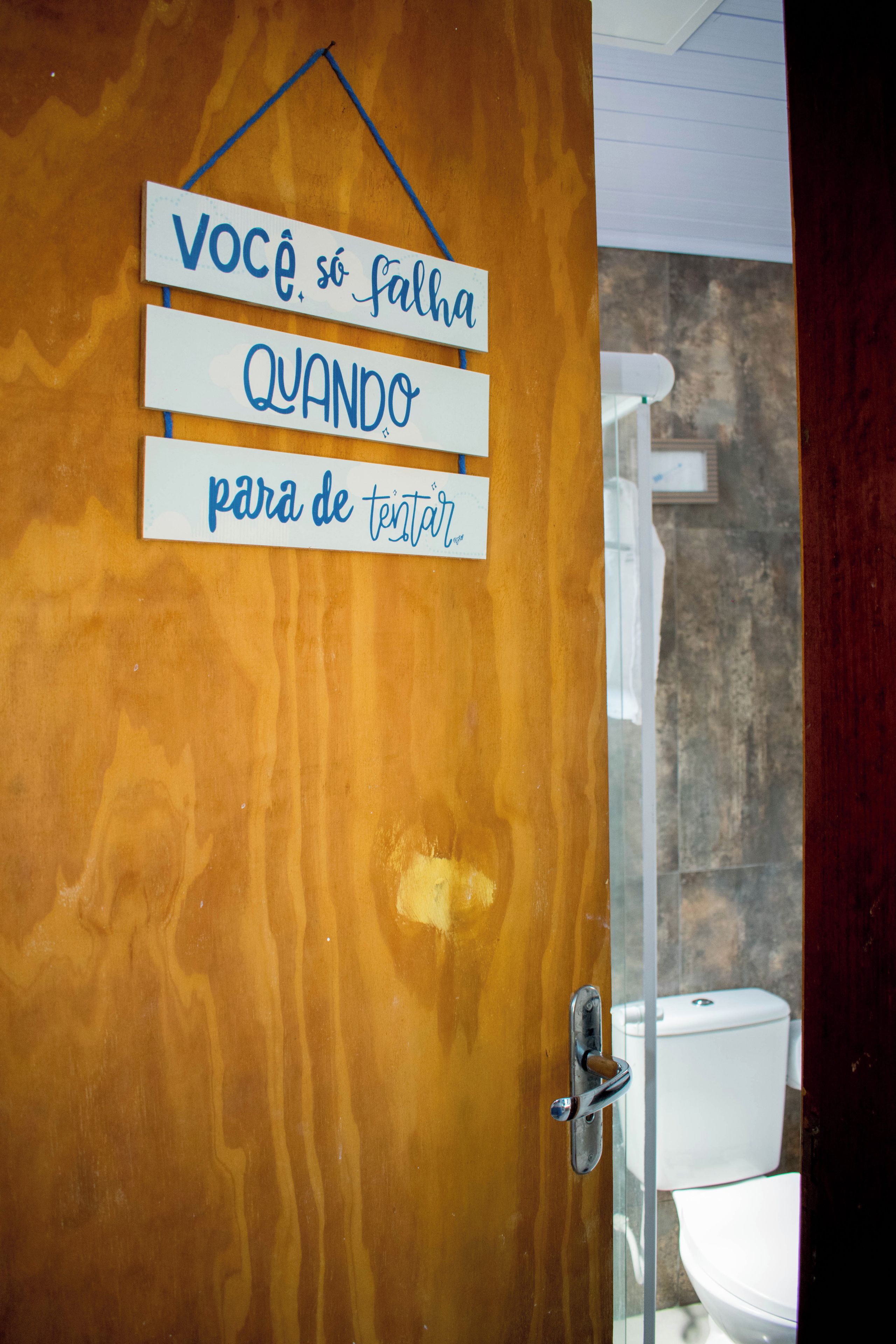 Una puerta de madera con un letrero que dice 'VOCÊ, só falha QUANDO para de tentar'.