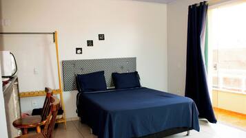 Un dormitorio con una cama, un escritorio y una silla.