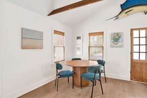 A dining area with a round wooden table, four chairs, and a large fish mounted on the wall. - Pearl Downtown (Mobile)