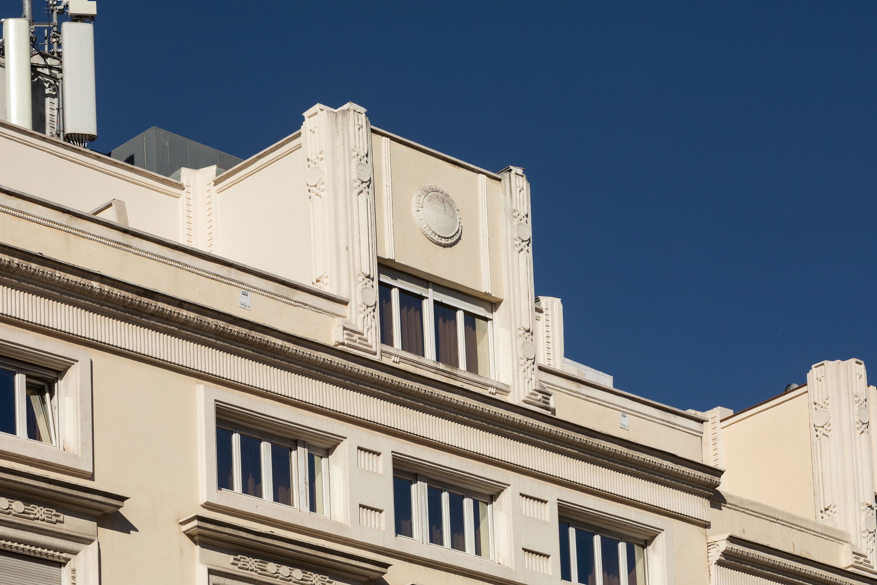 Een gebouw met klassieke architectuur, herkenbaar aan versierde zuilen en een klok.