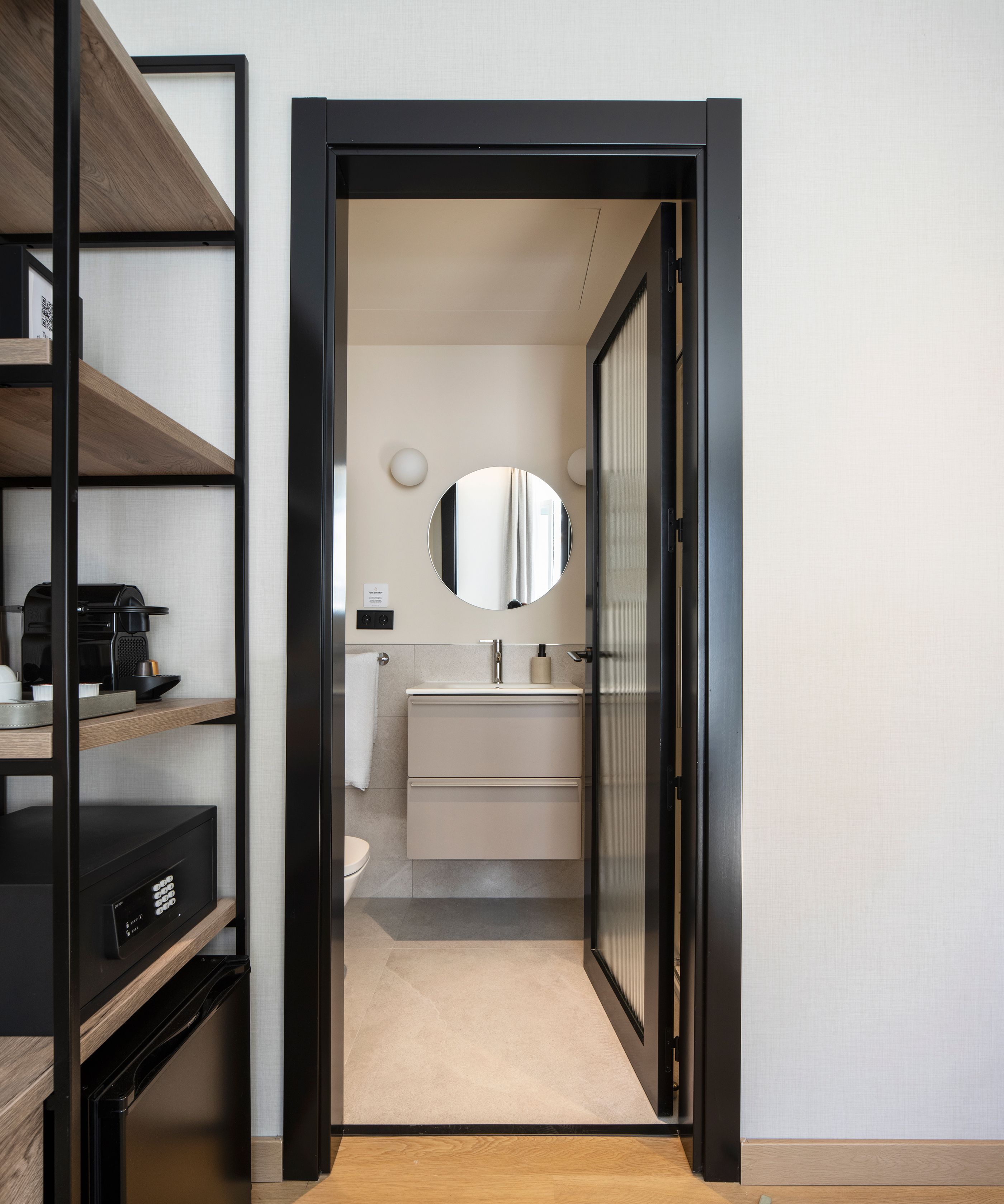 Een moderne badkamer met toilet, wastafel en spiegel.