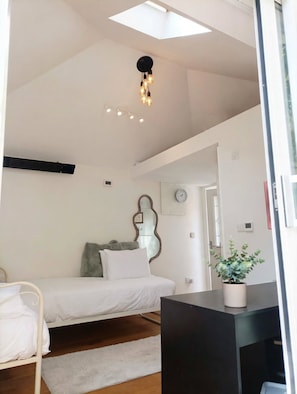 A bedroom with a bed, bedside table, and a potted plant. - Light-fitted studio, 7 mini walk to Elizabeth line (Slough)