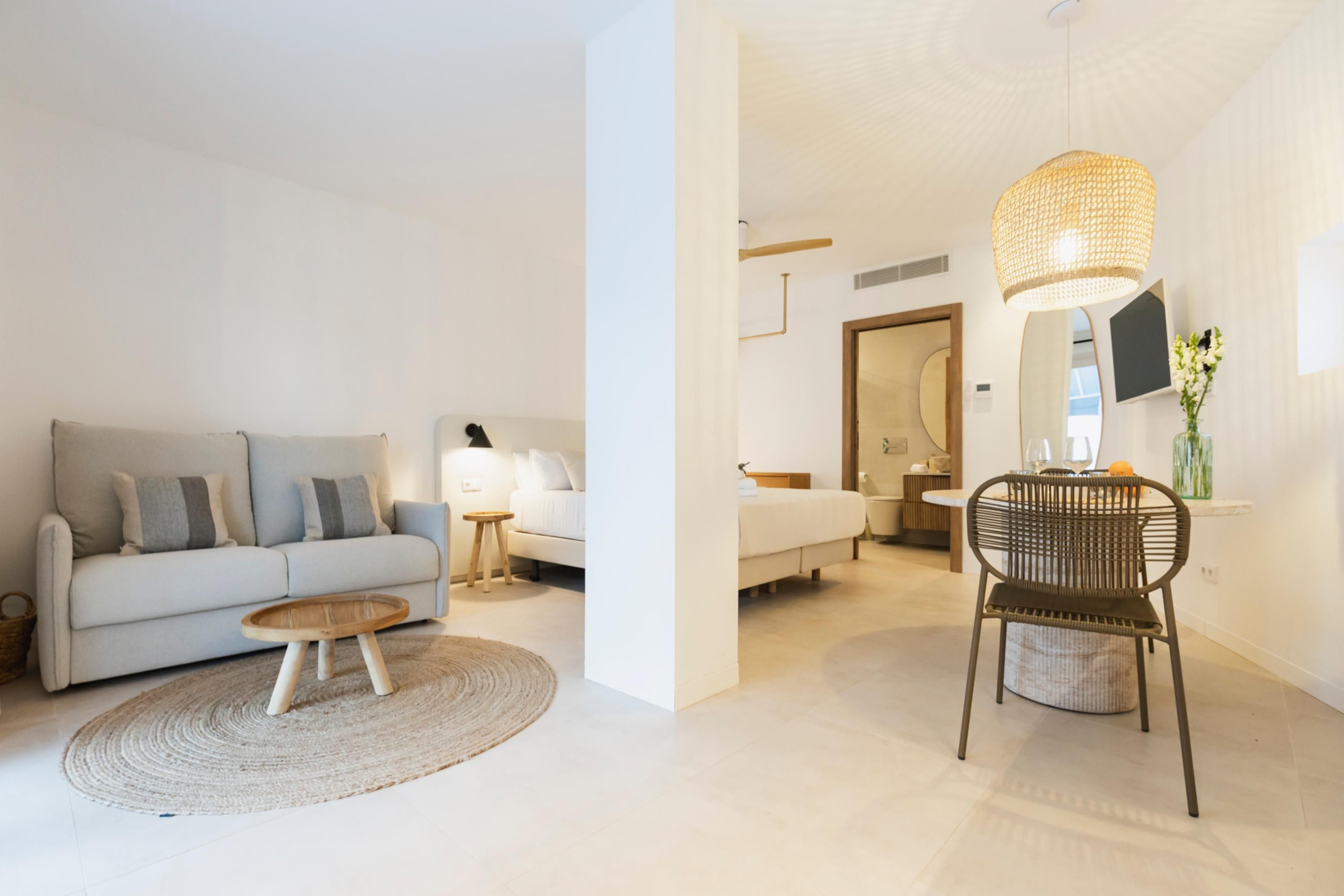 A modern living room with a sofa, a coffee table, and a wicker chair.