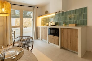 Eine moderne Küche mit Holzausstattung, einem eingebauten Ofen und einer grünen Fliesenfassade.
