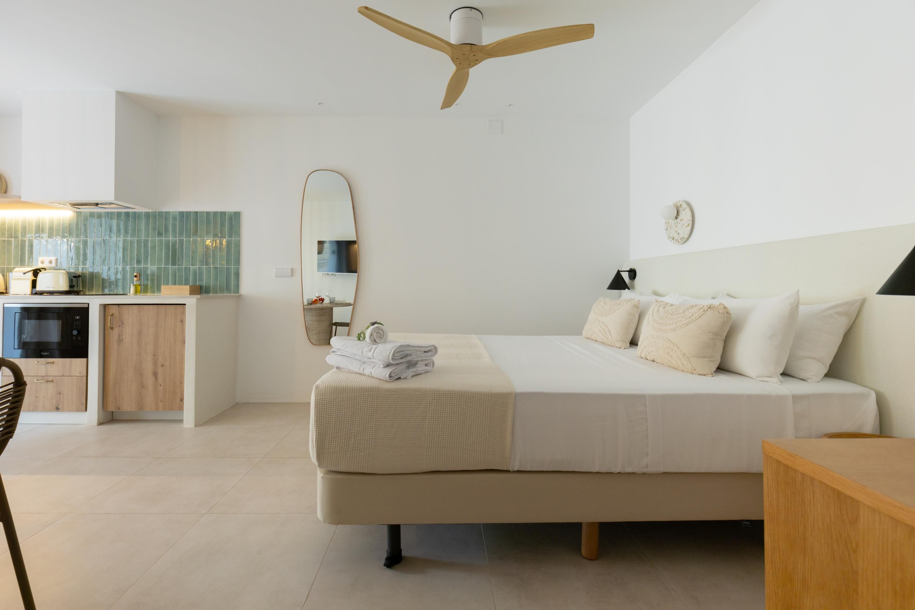 Een slaapkamer met een bed, nachtkastje en plafondventilator.