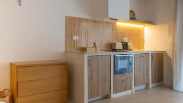A compact kitchen with a built-in microwave, a toaster, and a sink.