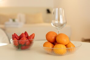 Mesa de jantar com uma tigela de vidro transparente cheia de laranjas e outra tigela de vidro transparente com morangos.