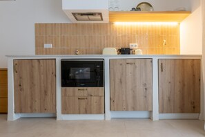 Cozinha com armários de madeira, lava-louças embutida e bancada com cafeteira e outros eletrodomésticos.