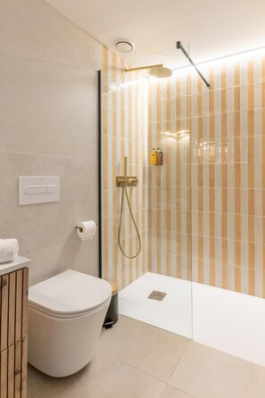 Et stilfuldt badeværelse med toilet, bruser og toiletpapirholder.