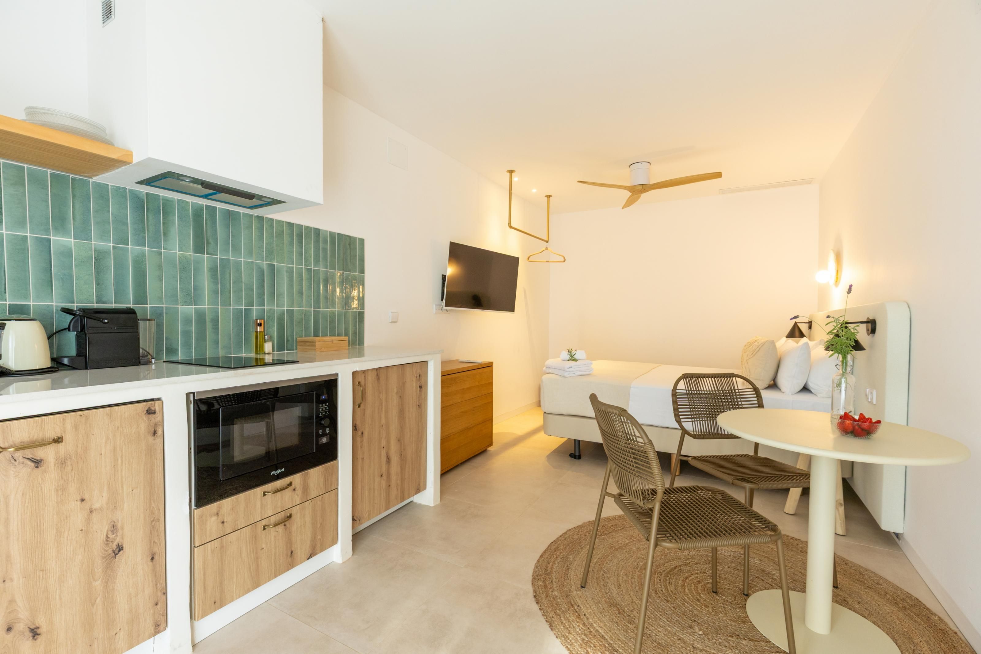 Una cocina moderna con microondas integrado, armarios de madera y salpicadero de azulejos.