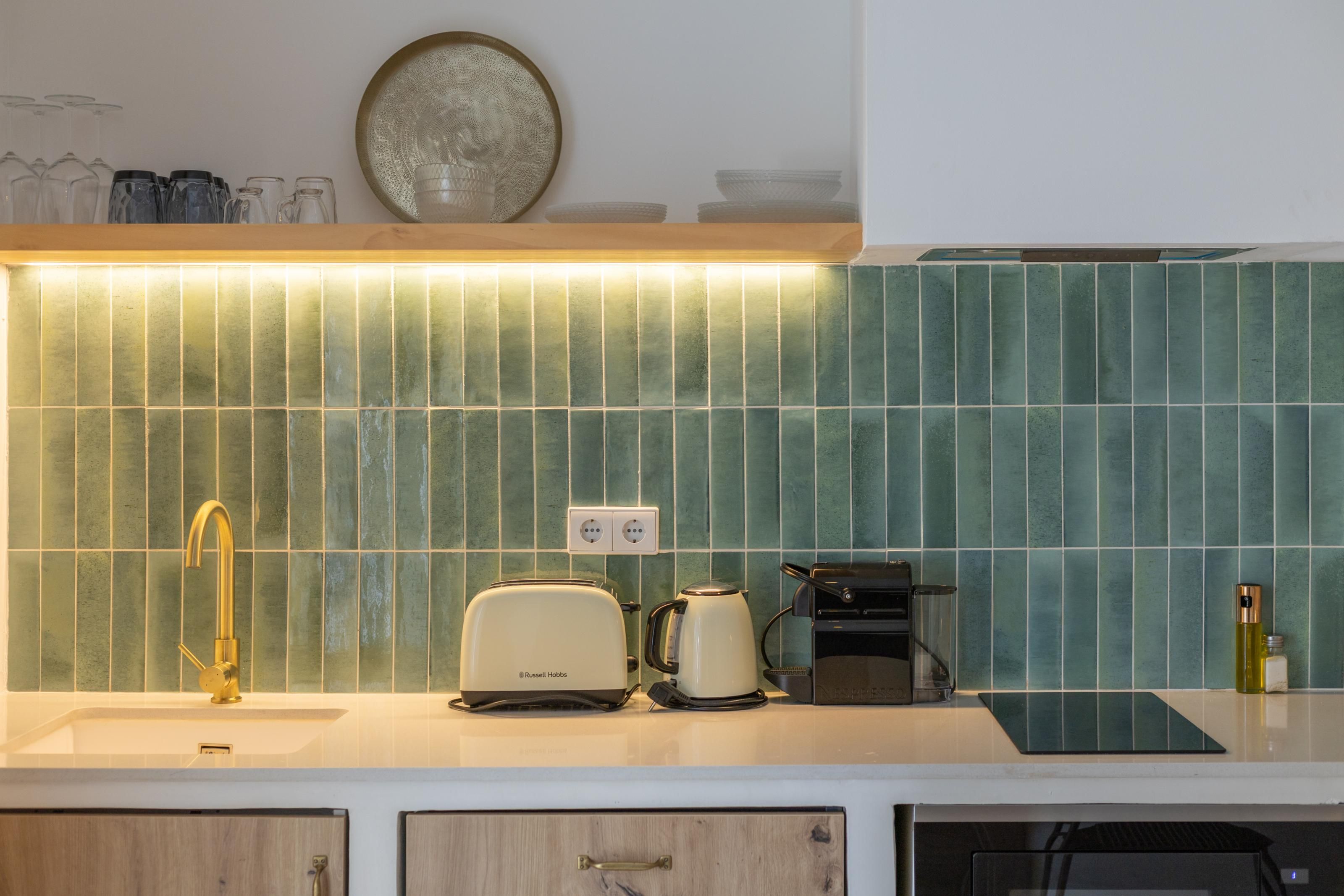 Cocina de diseño moderno, con un lavamanos, un tostador, una cafetera y un hervidor.