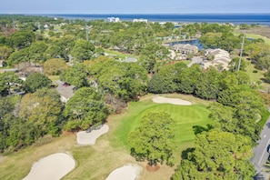 An aerial view of a golf course with sand bunkers, trees, and buildings in the background. - 🌴Sandestin Gulf FRONT~Covered Balcony~Pool-Amazing Views@Beachside Two🌴 (Miramar Beach)