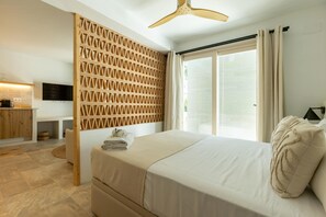 Quarto com cama, divisória de madeira, escrivaninha com televisão de tela plana e janela com cortinas.