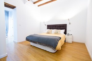Une chambre à coucher avec un lit, des tables de chevet et une fenêtre avec des rideaux.