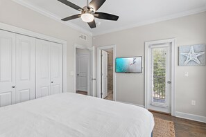 A bedroom with a bed, a ceiling fan, a television, and a door leading to a balcony. - 🌊Walk to Beach-Great Location-4BR Pet Friendly Beachwaves Driftwood🌊 (Miramar Beach)