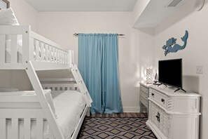 A bedroom with a bunk bed, a dresser, a television, and a blue curtain. - Gulf Views⛱️Walk to Beach-Kids Fountain~2 Pools-Ariel Dunes I 801-Morning Raes☀️ (Miramar Beach)