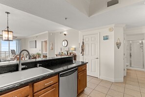 A modern kitchen with a large island, built-in dishwasher, and a view to the outside. - Gulf Views⛱️Walk to Beach-Kids Fountain~2 Pools-Ariel Dunes I 801-Morning Raes☀️ (Miramar Beach)