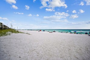 A beach with a clear sky, sandy shore, and a building in the background. - 🌊Beautiful Peek of the Gulf~Pools~Walk2Beach~On the Beach🌊 (Miramar Beach)