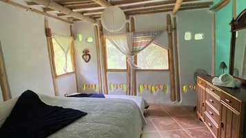 Quarto com uma cama, cômoda de madeira e janela com vista.