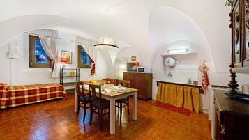 Een knus verblijf met een eethoek, kitchenette en een bed.