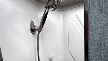 A shower with a handheld showerhead and a handheld hose.