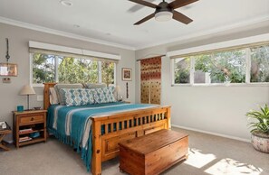 A bedroom with a bed, bedside tables, a ceiling fan, and large windows. - Executive Furnished Home  Pool  Sherman Oaks (Los Angeles)