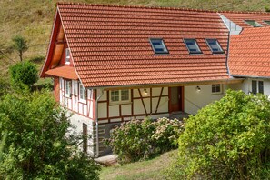 Ein traditionelles Fachwerkhäuschen mit einem geneigten roten Ziegeldach und Dachgauben.