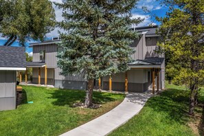 A residential area with modern houses, a paved driveway, and a tree. - Charming Riverfront Property Close to the Resort! Pet Friendly! (Steamboat Springs)