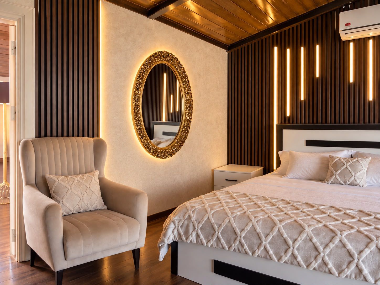 Une chambre moderne avec un grand lit, un coin salon avec un fauteuil, une table de chevet et un miroir fixé au mur.