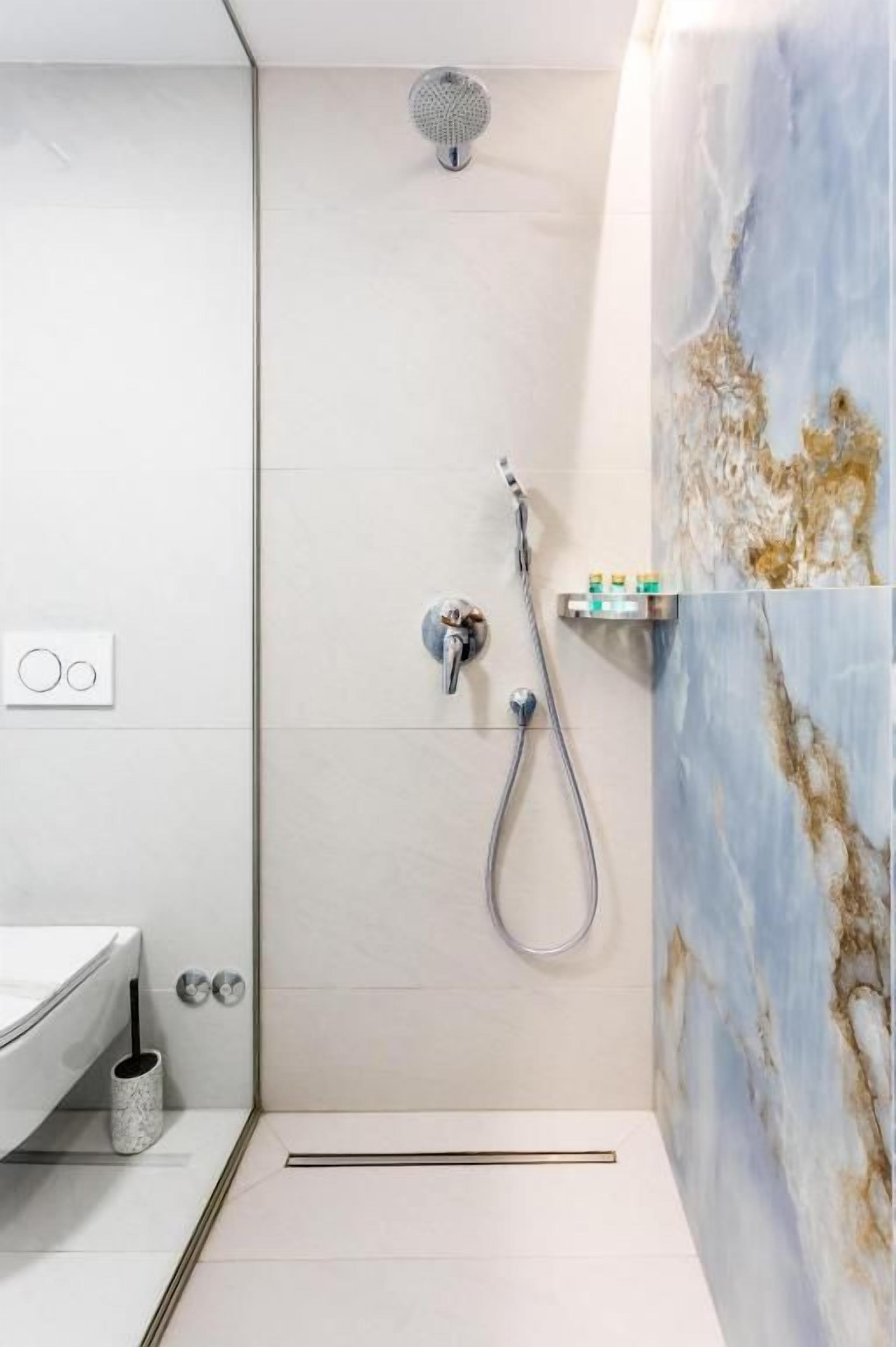 A modern bathroom with a shower, a toilet, and a sink.