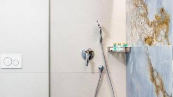A modern bathroom with a shower, a toilet, and a sink.