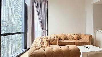 A modern living room with a large window, a tufted sofa, and a minimalist coffee table.