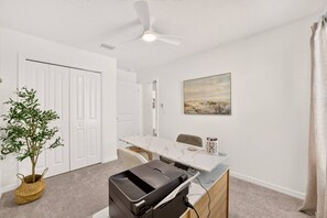 A room with a desk, chair, printer, and a ceiling fan. - Charming Fenced Eastport Cottage with Golf Cart (Wildwood)