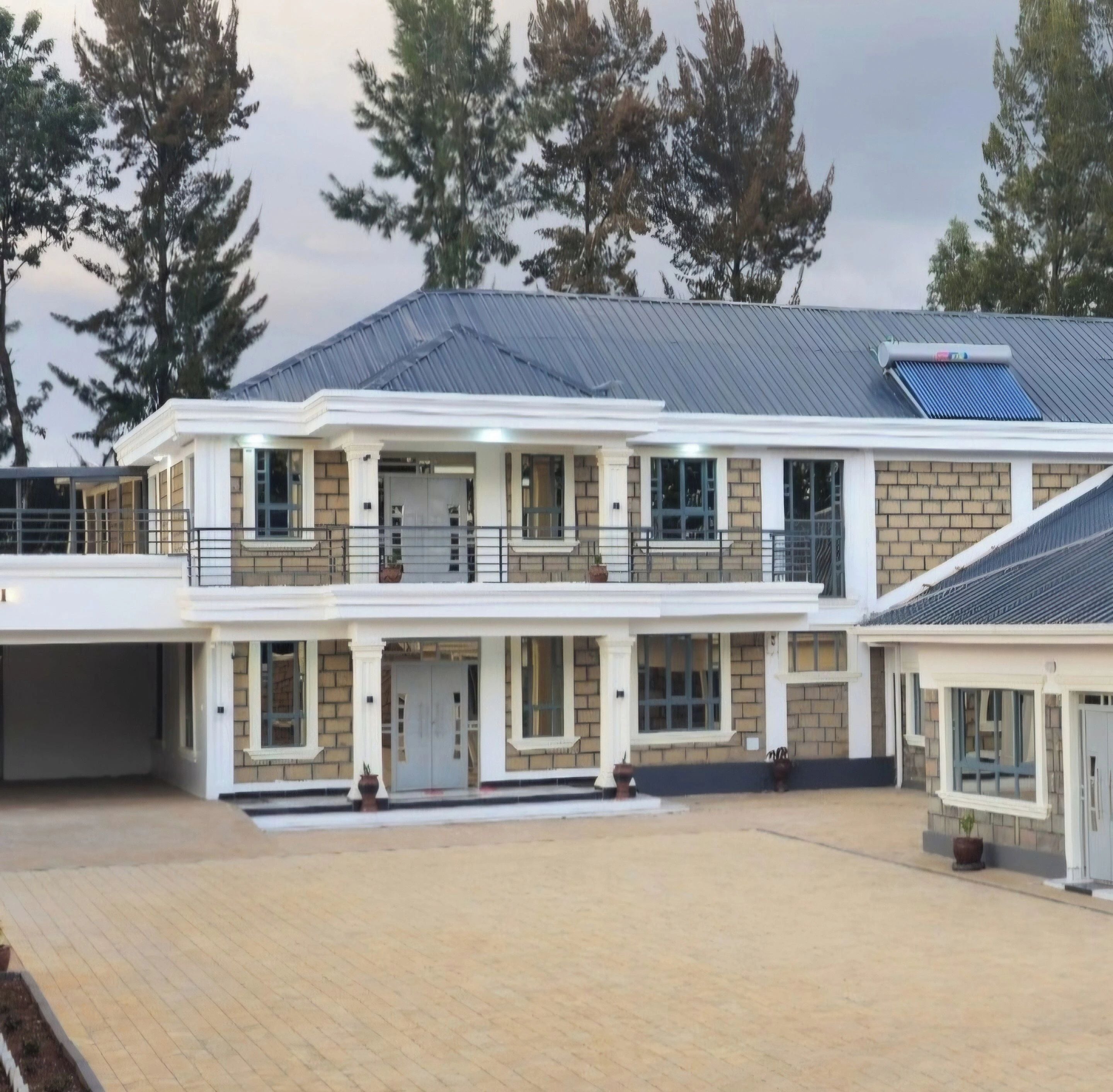 Een gebouw met twee verdiepingen, een plat dak, een overdekte ingang en een verharde oprit.