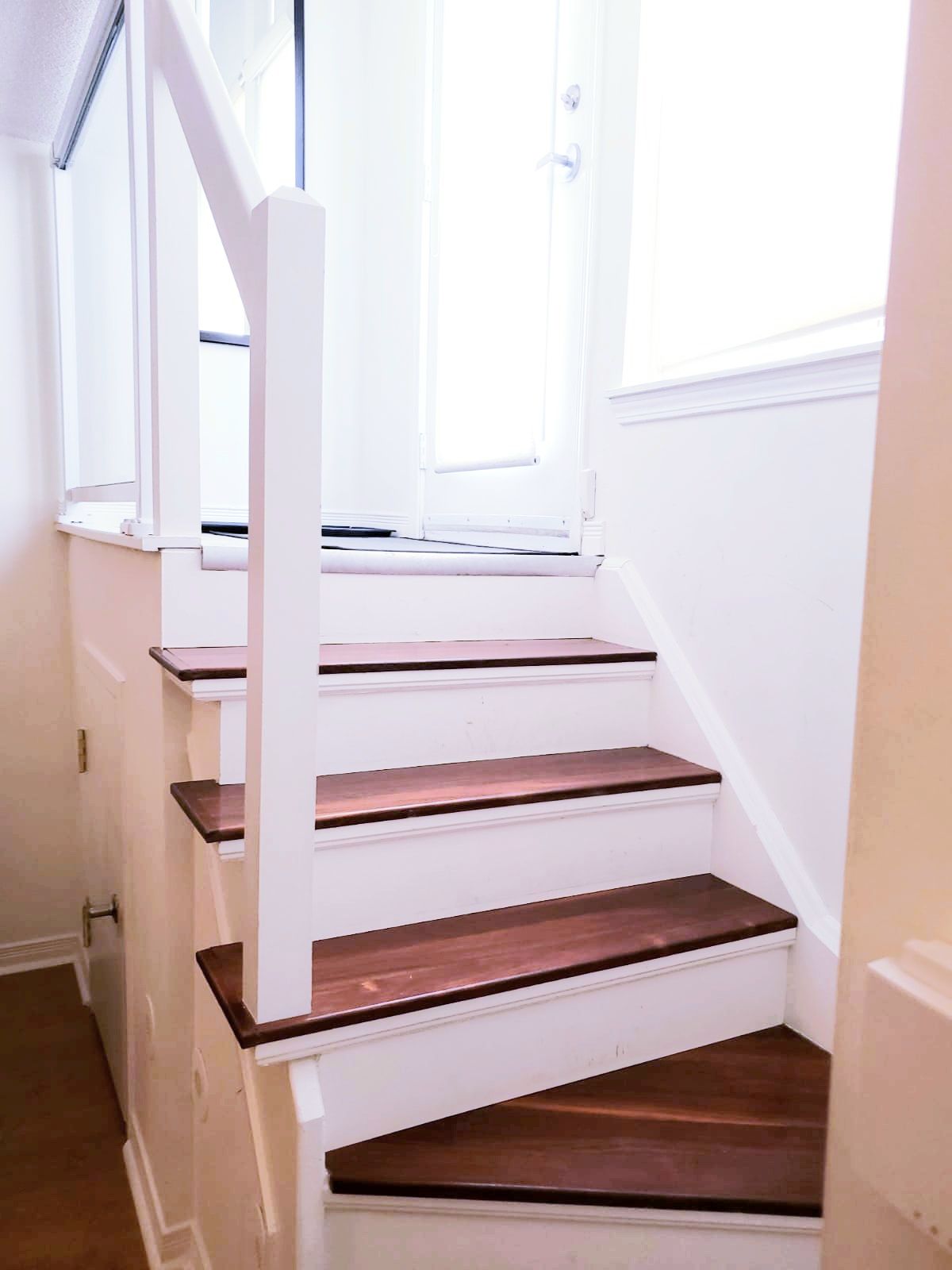 A staircase with white walls and wooden steps.