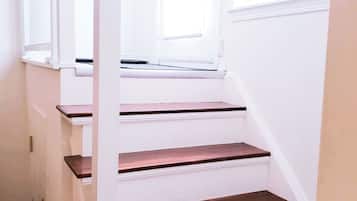 A staircase with white walls and wooden steps.