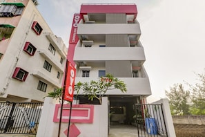 Un edificio de varios pisos con un letrero grande rojo y blanco que indica un hotel.