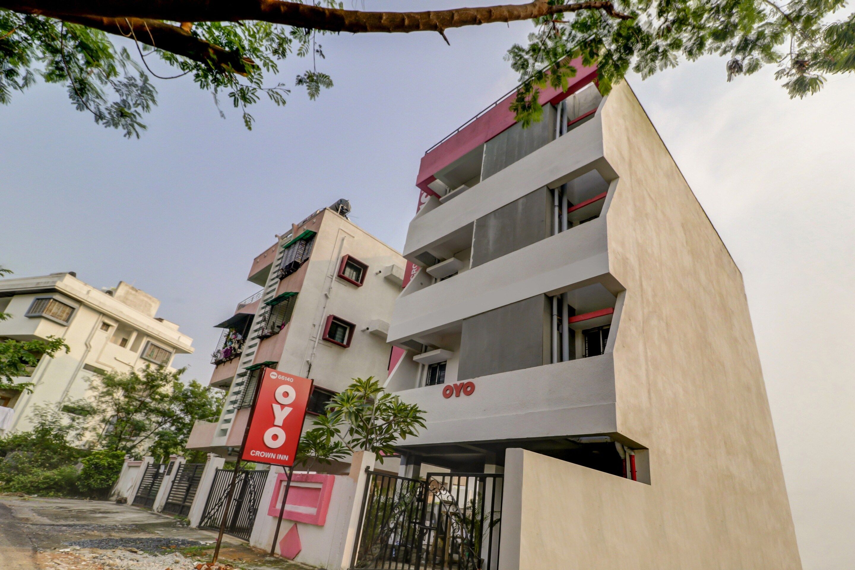A multi-story building with a prominent red sign indicating a hotel named 'OYO'.