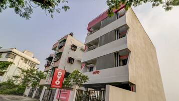 A multi-story building with a prominent red sign indicating a hotel named 'OYO'.