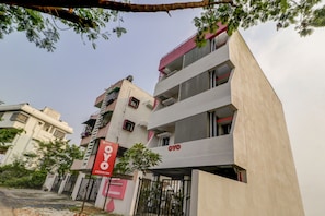 Un edificio de varios pisos con un letrero rojo llamativo que indica un hotel llamado 'OYO'.