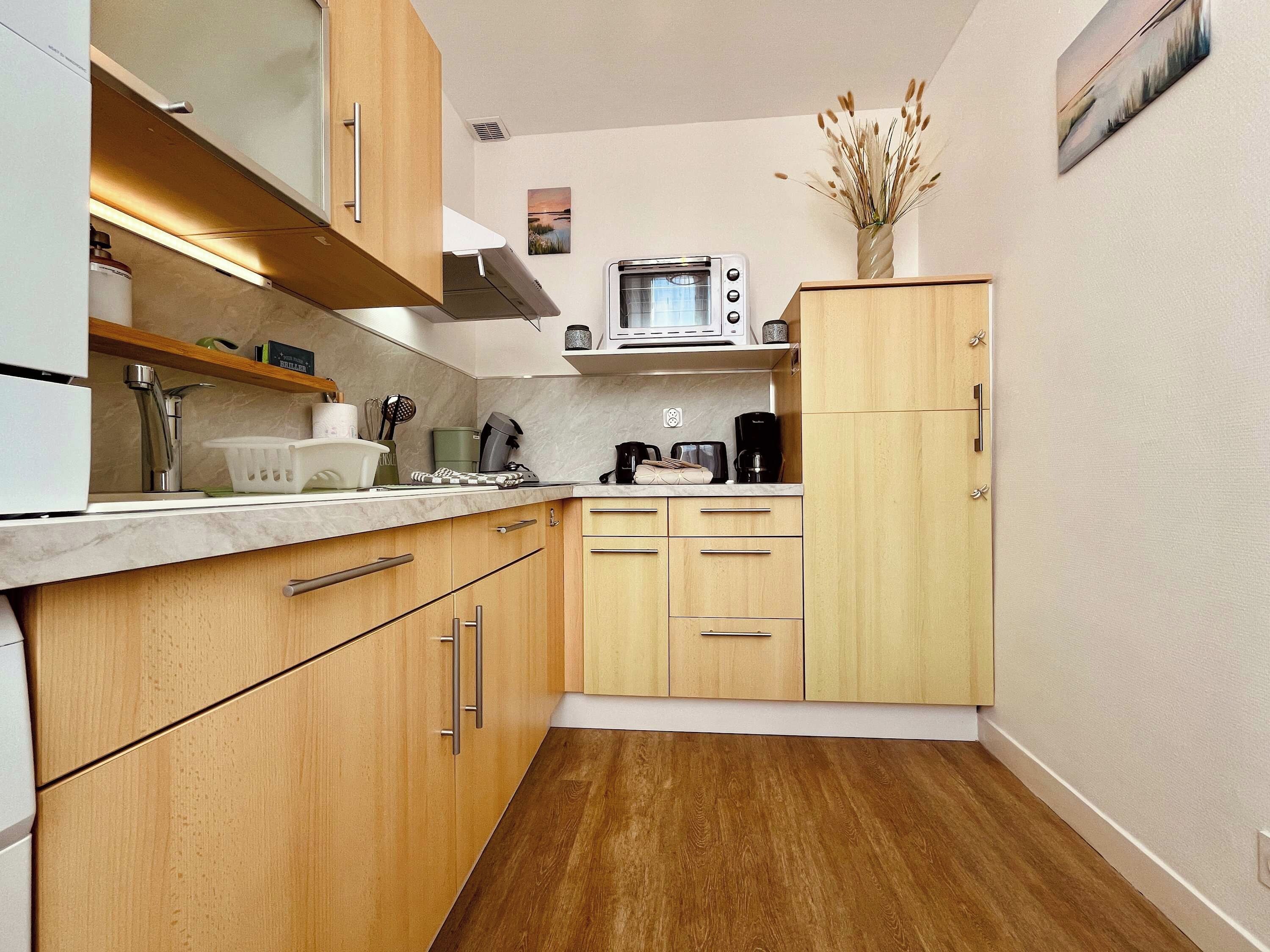A compact kitchen with wooden cabinets, a microwave, and a coffee maker.