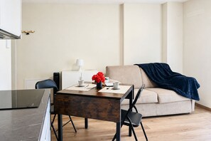 Ein modernes Wohnzimmer mit einer Couch, einem Couchtisch und einem Esstisch mit Stühlen.