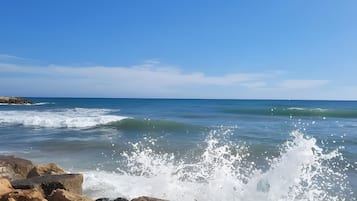 Un rivage rocheux où les vagues s’écrasent contre les rochers.