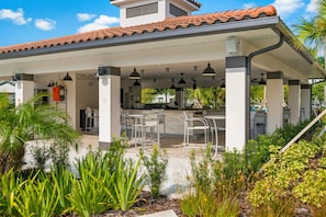 An outdoor patio area with a covered seating arrangement, a water feature, and a view of the surrounding greenery. - Stay Central, Explore More, Orlando 3BR Condo (Orlando)