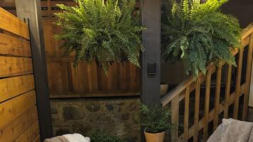A cozy seating area with two wicker chairs, a small table, and a potted plant.