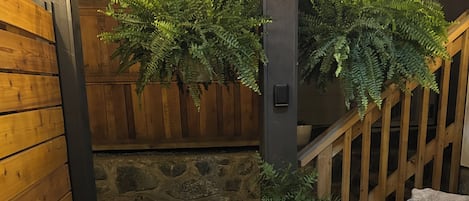 A cozy seating area with two wicker chairs, a small table, and a potted plant.