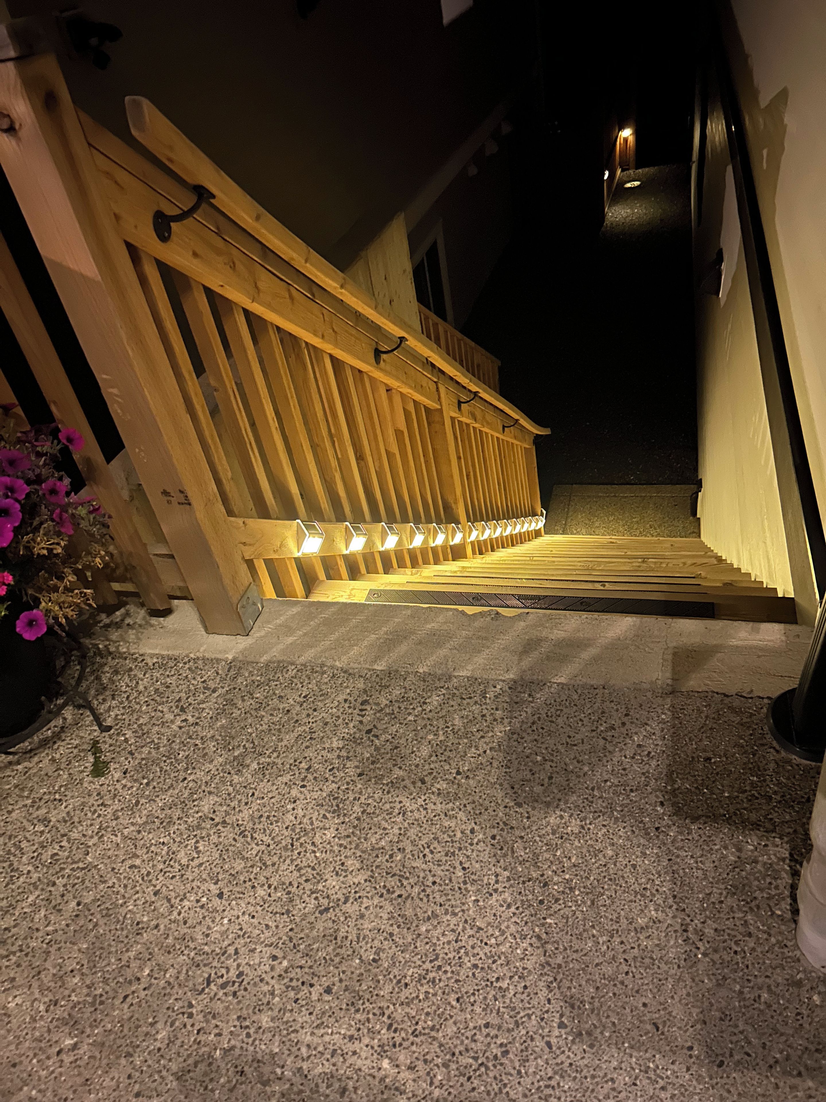 A staircase with wooden railings and a handrail, leading to a door.
