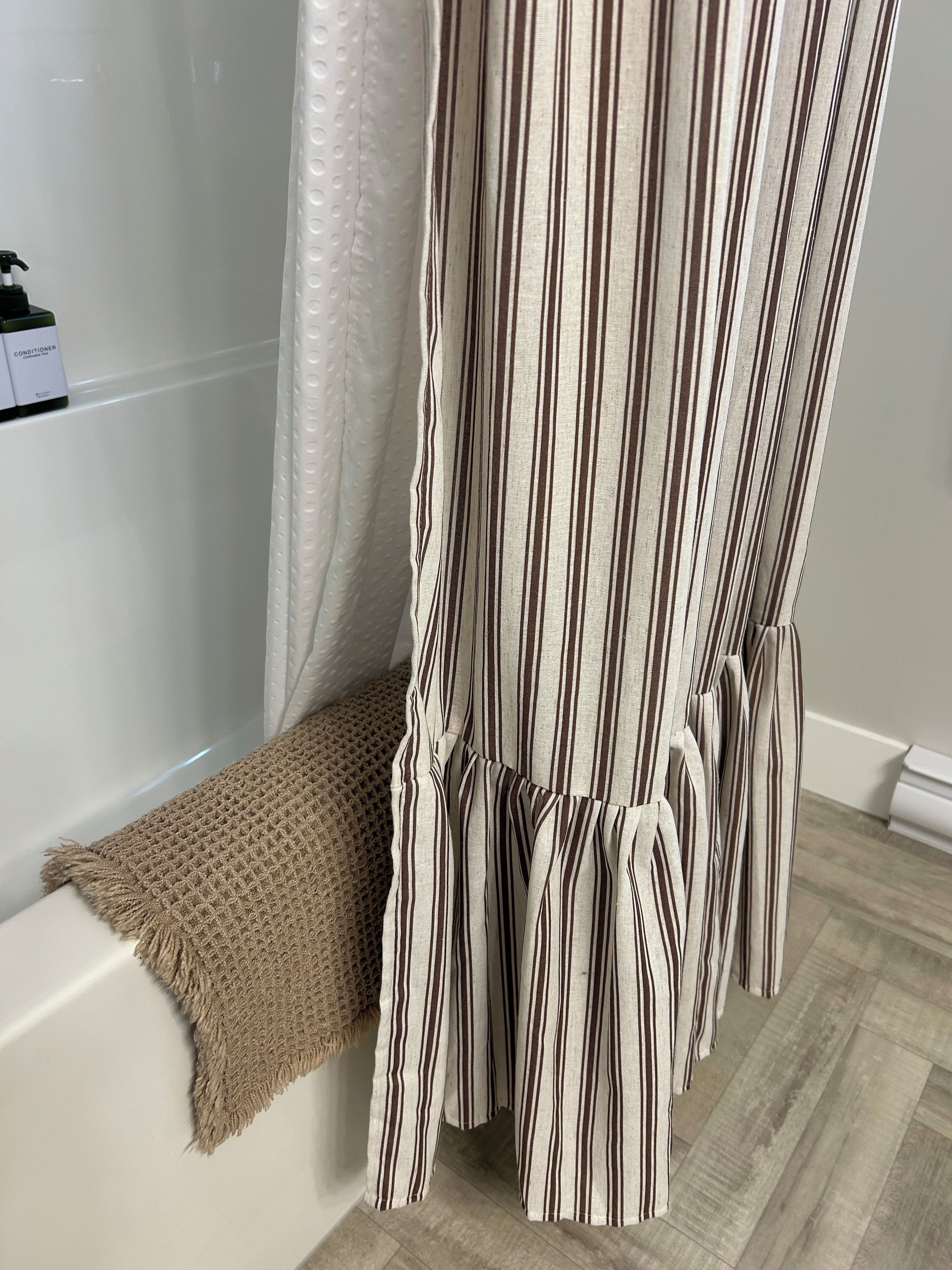 A bathroom with a bathtub, a shower curtain, and a towel.